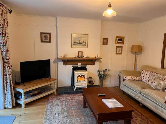 Cosy living room with mountain views, a wooden coffee table, sofa and a fireplace, providing a tranquil retreat.